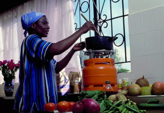African-Woman-Cooking-on-Orange-Cylinder-Indoor-2-1600x0-c-default.jpg